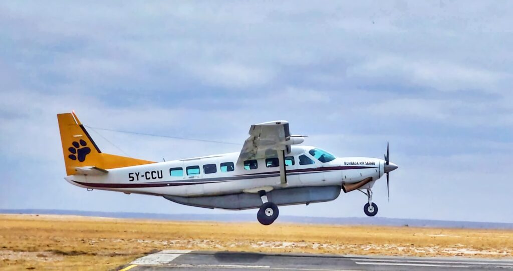 Small aircraft landing on Masai Mara airstrip on a fly-in safari from Nairobi