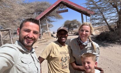 Family with safari guide at the Serengeti National Park entrance, Tanzania