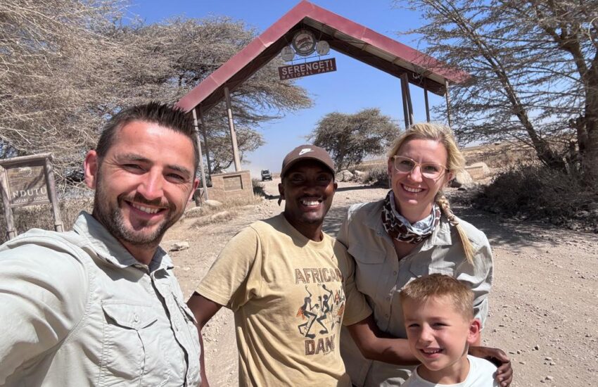 Family with safari guide at the Serengeti National Park entrance, Tanzania