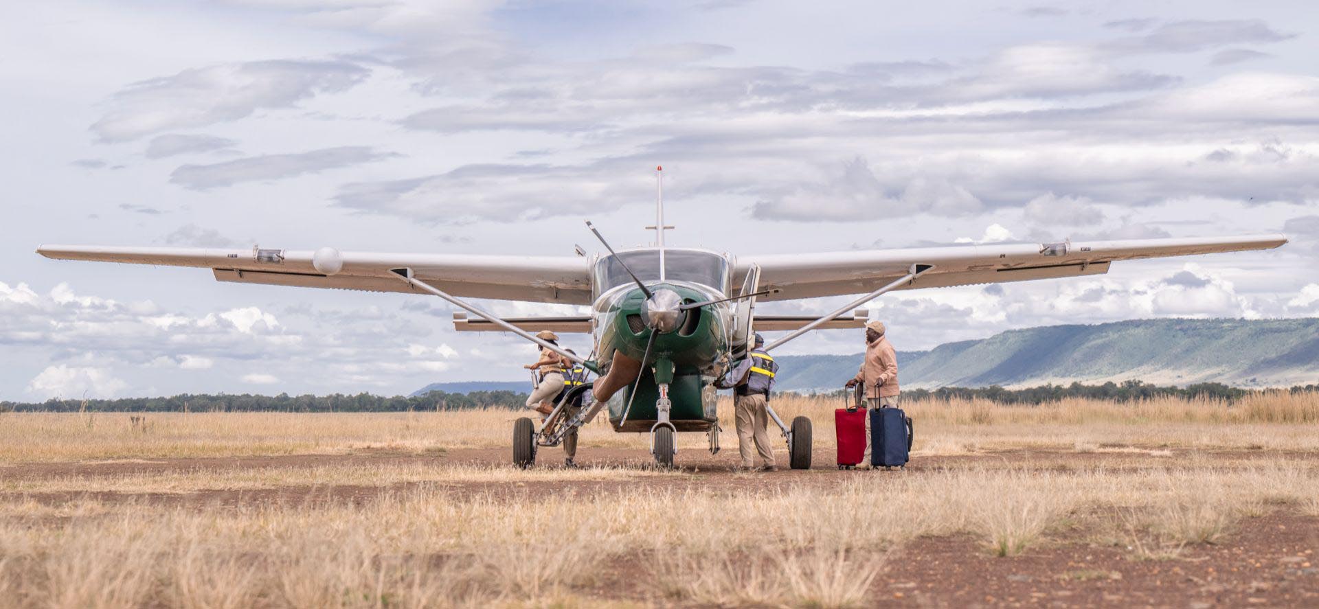 Small aircraft landing on Masai Mara airstrip on a fly-in safari from Nairobi