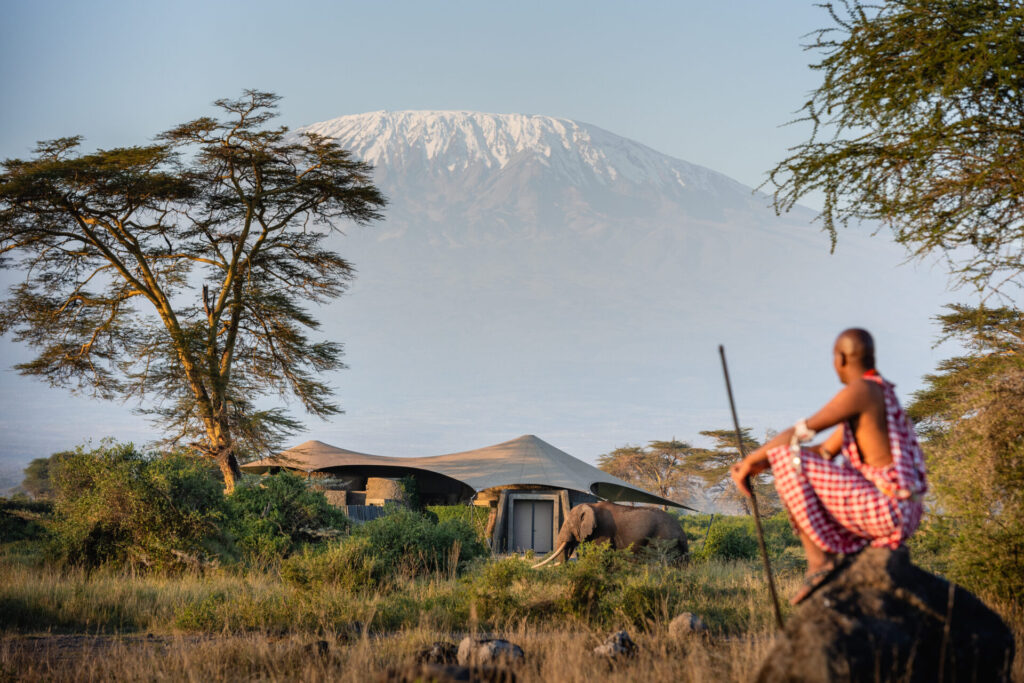 Kenya Honeymoon Safari at Amboseli with Mount Kilimanjaro, a Maasai warrior, and an elephant in the foreground.